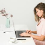woman sitting while using laptop